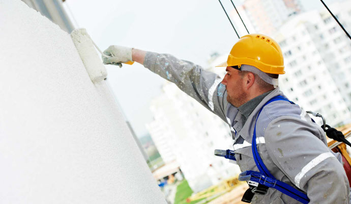 a professional painting the exterior of a building