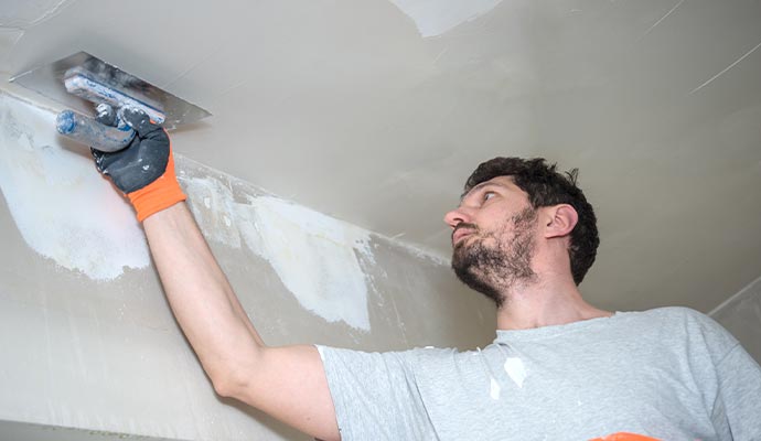 worker repairing concrete ceiling