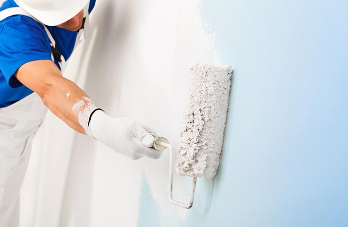 A painter painting a wall with a brush