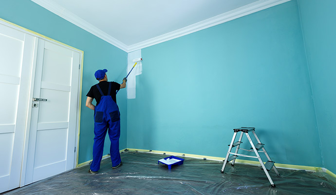 Person painting interior of a room