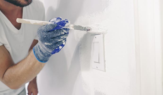 a professional repainting a wall