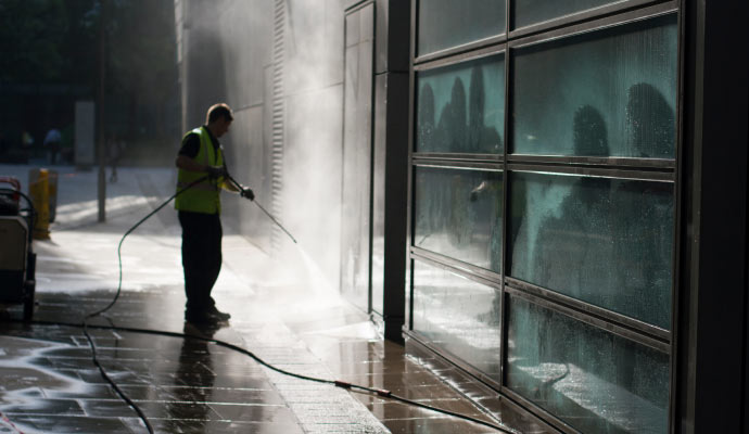 a person cleaning glass with pressure washing